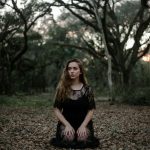 woman wearing black dress kneeling on ground