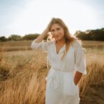 woman in white dress standing on brown grass field during daytime
