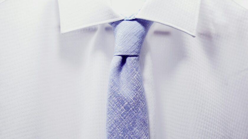 close up photo white collared shirt with blue necktie